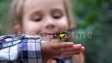 特写镜头。 一只蝴蝶在一个小女孩的手上<strong>展翅</strong>飞翔。 4K慢慢